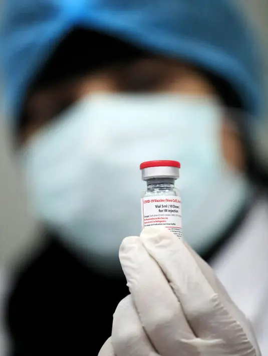 Pekerja laboratorium menunjukkan botol vaksin Sinovac di laboratorium Vacsera, Kairo, Mesir, Rabu (1/9/2021). Laboratorium Vacsera di Mesir membuat vaksin Sinovac China untuk mencegah penularan virus corona. (AFP/Khaled Desouki)