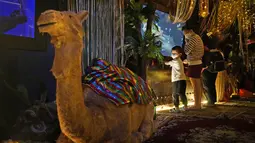 Seorang anak bermain di dekat dekorasi Ramadhan di Jakarta Aquarium and Safari di Jakarta (6/4/2022). Muslim di seluruh dunia merayakan minggu pertama Ramadhan, bulan paling suci dalam kalender Islam, di mana mereka menahan diri dari makan, minum dari fajar hingga senja. (AP Photo/Dita Alangkara)