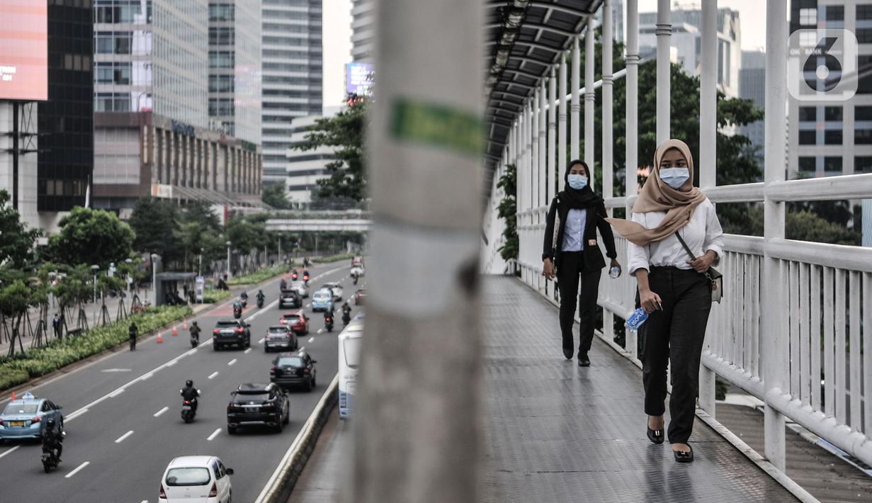 Pekerja melintasi jembatan penyeberangan orang saat jam pulang kantor di kawasan Sudirman, Jakarta, Senin (14/9/2020). Pengurangan aktivitas pekerja di perkantoran menjadi fokus utama Pemprov DKI Jakarta dalam penerapan PSBB pada 14-27 September 2020. (merdeka.com/Iqbal S. Nugroho)