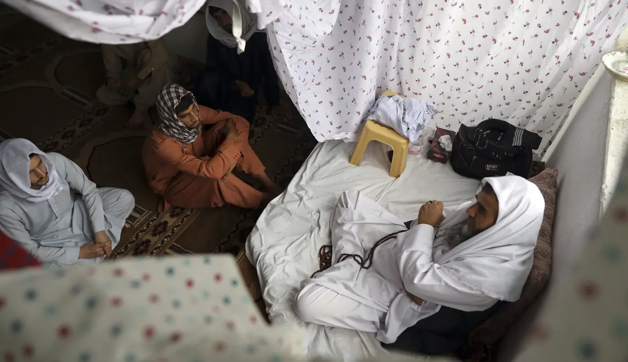 Seorang ulama berkonsultasi dengan jemaah selama Itikaf di masjid di Kabul, Afghanistan, Selasa (4/5/2021). Bulan Ramadan telah memasuki hari-hari terakhirnya. Untuk mengejar sebanyak mungkin kebaikan di bulan suci ini, banyak umat Muslim yang melakukan iktikaf. (AP Photo/Rahmat Gul)
