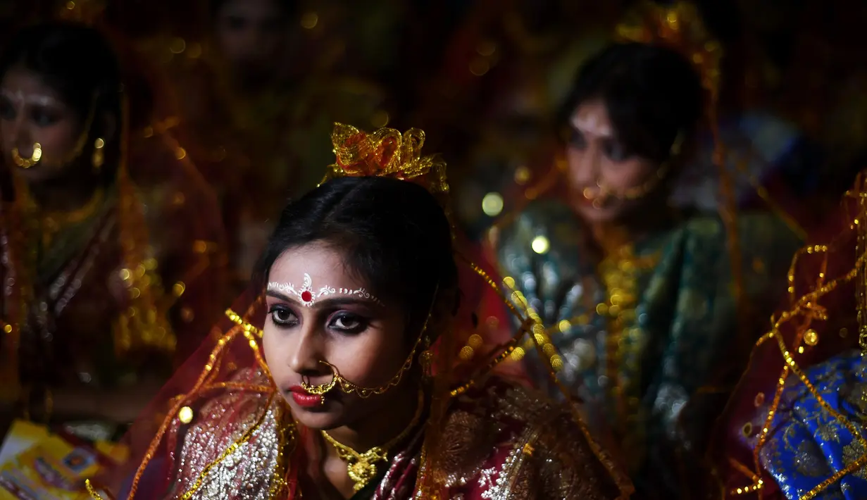 Sejumlah wanita calon pengantin bersiap mengikuti upacara pernikahan massal di Kolkata, India (14/2). Acara nikah massal ini diselenggarakan oleh LSM setempat yang bertujuan untuk merayakan Hari Valentine. (AFP Photo/Dibyangshu Sarkar)