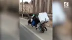 Sepeda motor berbentuk tak biasa mengangkut 7 anggota keluarga dan sebuah lemari es. Kendaraan itu melaju di jalanan Kota Chong Qing.