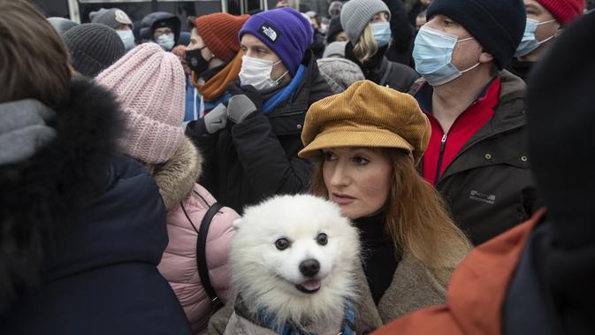 Seorang wanita dengan anjingnya berjalan-jalan di Lapangan Pushkin selama protes terhadap pemenjaraan pemimpin oposisi Alexei Navalny di Moskow, Rusia, Sabtu (23/1/2021). (AP Photo/Pavel Golovkin)