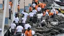 Prajurit Pusat Hidrografi dan Oseanografi TNI AL bersama petugas keamanan Ancol membersihkan sampah di sepanjang Pantai Ancol, Jakarta, Selasa (22/1). Kegiatan itu dilakukan mulai dari Pantai Lagoon hingga dermaga Marina. (Merdeka.com/Iqbal S. Nugroho)