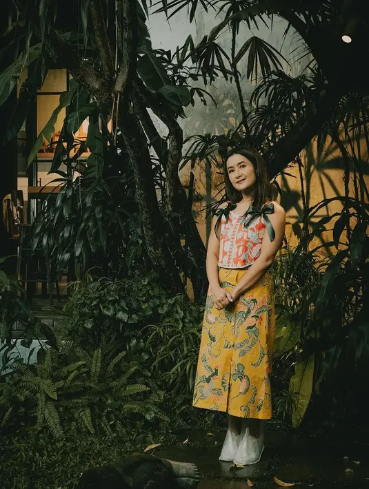 Widi Mulia dengan batik corset top warna oranye yang dipadukan kain kulot berwarna kuning. [IG/widimulia]