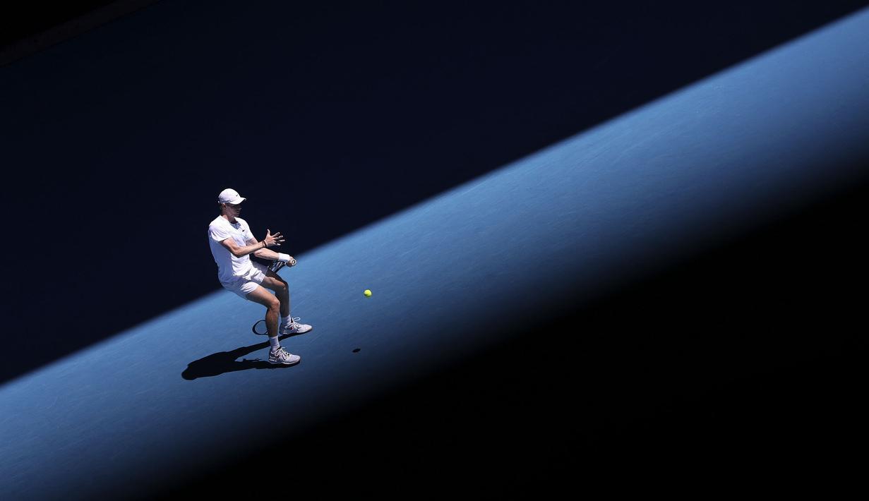 Petenis Kanada, Denis Shapovalov melakukan pukulan balik saat melawan petenis Spanyol, Rafael Nadal dalam pertandingan perempat final tunggal putra pada hari kesembilan turnamen tenis Australia Terbuka di Melbourne pada 25 Januari 2022.
(AFP/Martin Keep)