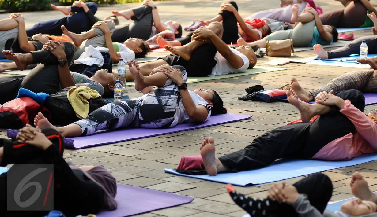 Sejumlah perempuan pegiat antikorupsi melakukan yoga jelang aksi penyampaian surat terbuka di Taman Suropati, Jakarta, Minggu (6/12). Kegiatan ini juga bentuk peringatan Hari Anti korupsi. (Liputan6.com/Helmi Fithriansyah)