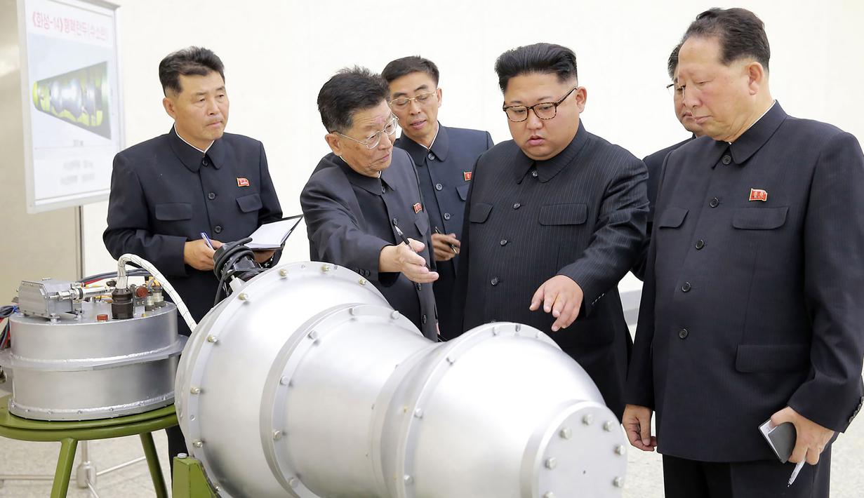 Kim Jong-un berbincang dengan para peneliti saat meninjau pembuatan bom hidrogen pada 3 September 2017. Bom ini diklaim berkekuatan hingga ratusan kiloton ini dibuat dengan berbagai komponen produksi dalam negeri. (AFP Photo/Kcna Via Kns/Str)