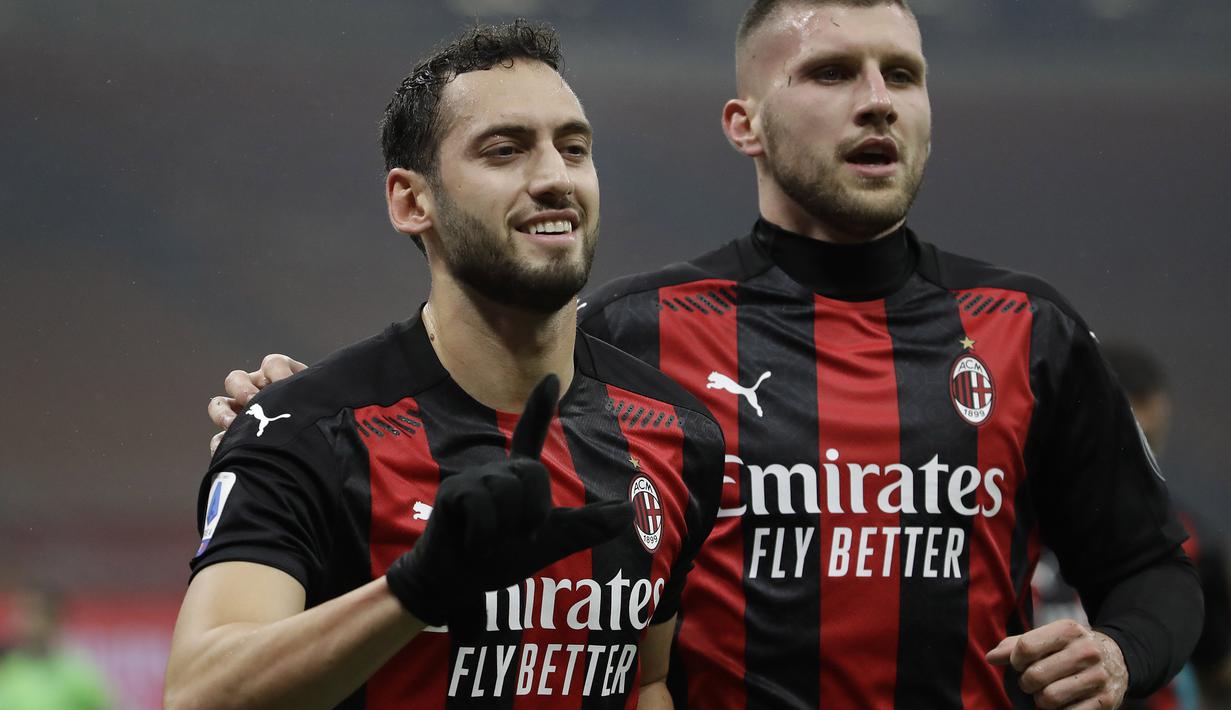 Gelandang AC Milan, Hakan Calhanoglu (kiri) berselebrasi usai mencetak gol ke gawang Lazio di menit ke-17 pada pertandingan lanjutan Liga Serie A Italia di stadion San Siro, Italia, Kamis (24/12/2020). (AP Photo/Luca Bruno)