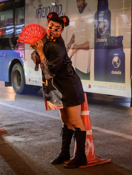 Seorang anggota komunitas LGBTQ berpose untuk berfoto di jalan yang didekorasi untuk menyambut Tahun Baru Imlek di Chinatown Bangkok (9/2/2021). (AFP/ Mladen Antonov)