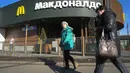 Perempuan berjalan melewati restoran McDonald's yang tertutup untuk pengunjung di St. Petersburg, Rusia, Selasa (15/3/2022). Gerai makanan siap saji McDonald's resmi menutup 850 gerainya yang beroperasi di Rusia pada 14 Maret 2022. (AP Photo)