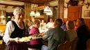 Kathi Kink mengantar pesanan makanan pengunjung di restoran 'Zum Goldenen Tal' di Weyarn, Jerman. Foto diambil pada 1 Februari 2015. (REUTERS/Michaela Rehle)