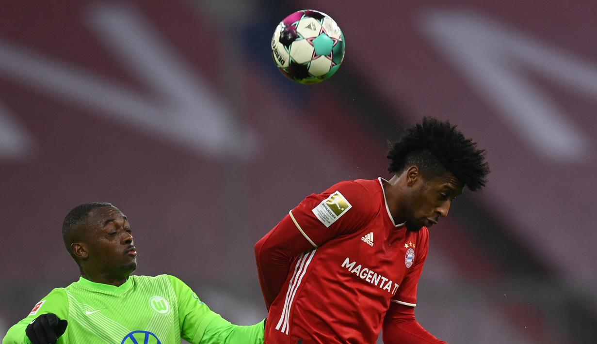 Penyerang Bayern Munchen, Kingsley Coman, berebut bola dengan bek Wolfsburg, Jerome Roussillon, pada laga lanjutan Liga Jerman di Allianz Arena, Kamis (17/12/2020) dini hari WIB. Bayern Munchen menang 2-1 atas Wolfsburg. (AFP/Christof Stache/pool)