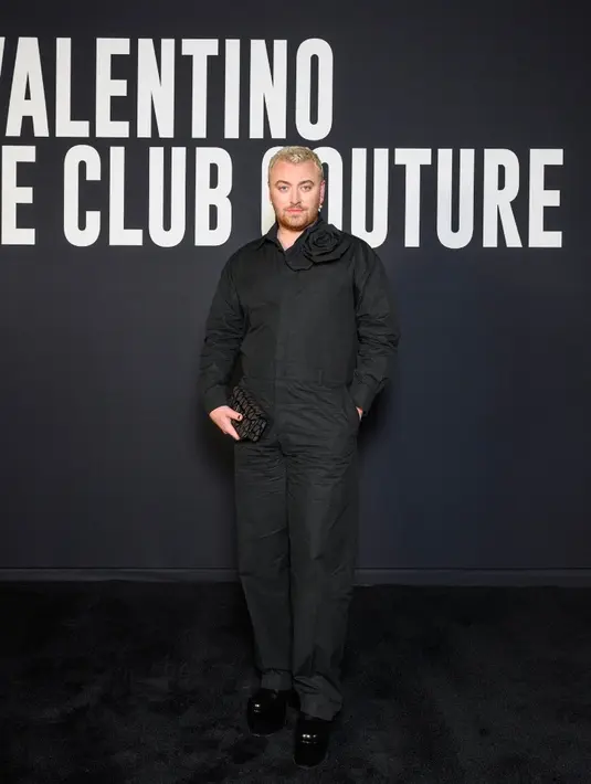 Sam Smith mengenakan kemeja dengan detail bunga dan celana warna hitam yang dirancang khusus untuknya oleh Direktur Kreatif Pierpaolo Piccioli. Ia membawa tas dan sepatu koleksi Valentino Garavani Loco. Credit: Valentino/SGP Italia