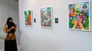 Pengunjung menyaksikan karya lukis yang bertajuk 'Membangun Harmoni' di Museum Basoeki Abdullah, Jakarta, Sabtu (18/12/2021). 'Membangun Harmoni' tersebut merupakan hasil karya lomba dari pelajar di tingkat SD, SMP, hingga SMA. (Liputan6.com/Herman Zakharia)