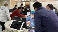 Seorang pekerja dengan alat pelindung merawat pengunjung di unit gawat darurat Rumah Sakit Rakyat Langfang No.4, Kota Bazhou, Provinsi Hebei, China, 22 Desember 2022. Para ahli mengatakan China dapat menghadapi lebih dari satu juta kematian akibat COVID-19 tahun depan. (AP Photo)