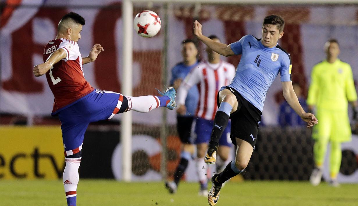 Gelandang Uruguay, Federico Valverde, berebut bola dengan bek Paraguay, Jorge Moreira, pada laga kualifikasi piala dunia 2018 di Stadion Defensores del Chaco, Rabu (6/9/2017). Uruguay menang 2-1 atas Paraguay. (AP/Jorge Saenz)
