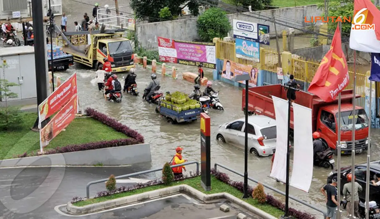 Air kali yang meluap ke jalan raya setinggi 40 cm ini membuat akses di Jl.Raden Saleh Karang Tengah Ciledug ini akses yang mengarah Puri Kembangan menuju Ciledug terhambat (Liputan6.com/Andrian M Tunay)