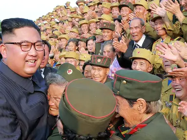 Pemimpin Korea Utara Kim Jong-un tersenyum saat bertemu veteran perang pada acara Konferensi Veteran Perang Nasional ke-5 di pemakaman perang Martyrs Cemetery di Pyongyang (27/7). (KCNA Via KNS/AFP)