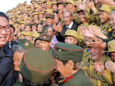 Pemimpin Korea Utara Kim Jong-un tersenyum saat bertemu veteran perang pada acara Konferensi Veteran Perang Nasional ke-5 di pemakaman perang Martyrs Cemetery di Pyongyang (27/7). (KCNA Via KNS/AFP)