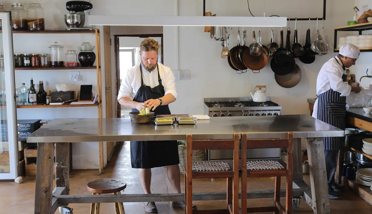 Chef Kobus van der Merwe menyiapkan hidangan di restoran Wolfgat di Paternoster, Afrika Selatan, 24 Februari 2019. Restoran ini menjadi istimewa karena semua bahan baku didapatkan secara liar dan alami dari area sekitar restoran. (Halden Krog/AFP)