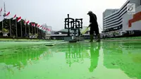 Pekerja membersihkan kolam di kompleks Parlemen, Senayan, Jakarta, Senin (31/7). Bersih - bersih ini dilakukan tiga bulan sekali untuk perawatan Gedung MPR/DPR/DPD. (Liputan6.com/Johan Tallo)