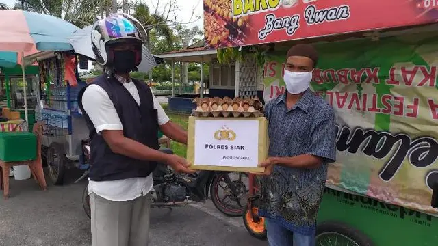 Tukang ojek mengantarkan paket sembako dari Polres Siak bagi masyarakat terdampak covid-19.