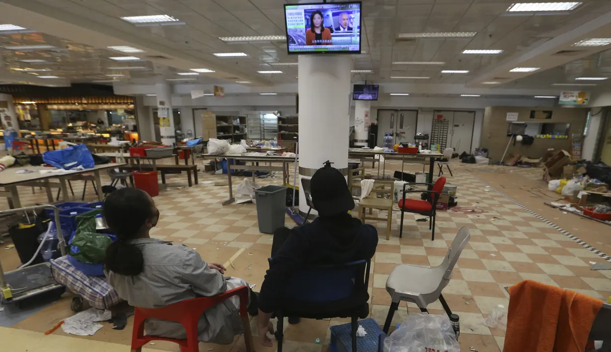 Para pengunjuk rasa menonton TV di dalam kampus Universitas Politeknik Hong Kong di Hong Kong (22/11/2019). Sebagian besar pengunjuk rasa yang mengambil alih universitas minggu lalu telah pergi, tetapi jumlah yang tidak diketahui tetap di dalam selama berhari-hari. (AP Photo/Achmad Ibrahim)