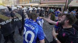 Para polisi terlibat kericuhan dengan para fans menjelang laga final Conference League 2024/2025 antara Real Betis melawan Chelsea di sekitar restoran kota Wroclaw, Polandia, Selasa (27/05/2025) waktu setempat. (AP Photo/Czarek Sokolowski)