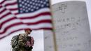 <p>Banyak sukarelawan memasang bendera Amerika Serikat pada makam personel militer di pemakaman nasional. (AP Photo/Andrew Harnik)</p>