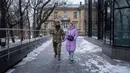 Tentara Ukraina Vitalii Khroniuk dan rekannya Anna Sokurenko berjalan di jalan setelah kunjungan mereka ke klinik kesuburan di Kiev, Ukraina, 4 Februari 2023. Saat Khroniuk terbaring telungkup di tanah berlindung dari tembakan artileri Rusia, prajurit Ukraina hanya memiliki satu penyesalan : Dia belum pernah punya anak. (AP Photo/Evgeniy Maloletka)