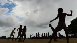 Anak-anak Rohingya bermain sepak bola di kamp pengungsi Kutupalong di Ukhia, Bangladesh, 19 Juli 2018. Bendera Argentina dan Brasil bahkan masih berkibar berdampingan dengan bendera Bangladesh di kamp pengungsi terbesar di dunia. (AFP/Munir UZ ZAMAN)
