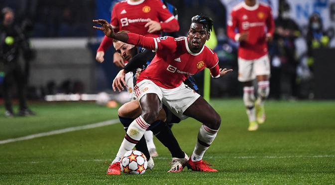 Gelandang Manchester United (MU), Paul Pogba (kanan) berebut bola dengan gelandang Atalanta, Teun Koopmeiners pada matchday keempat Liga Champions di Stadion Gewiss, Rabu dini hari WIB (3/11/2021). Atalanta berhasil menahan imbang MU 2-2. (Marco BERTORELLO / AFP)