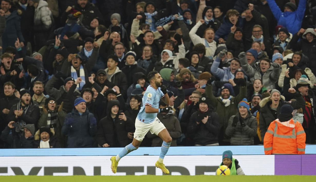 Pemain Manchester City, Riyad Mahrez, melakukan selebrasi usai mencetak gol ke gawang Tottenham Hotspur pada laga Liga Inggris di Stadion Etihad, Kamis (19/1/2023). Riyad Mahrez menjadi bintang kemenangan tim tuan rumah usai mencetak dua gol dan satu assist. (AP Photo/Dave Thompson)