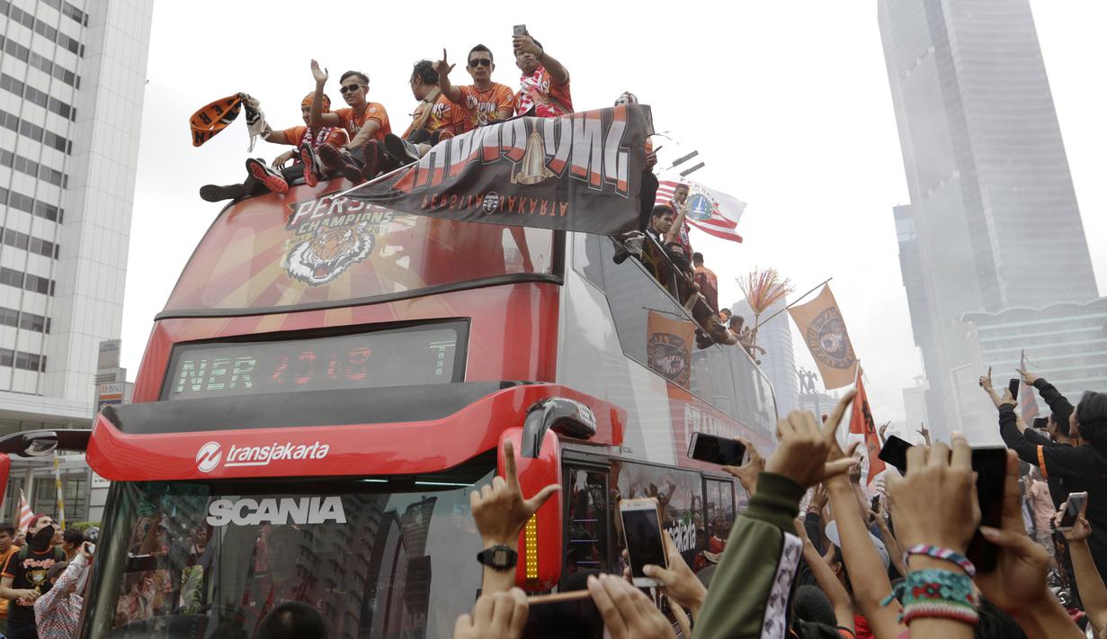 Pemain Persija Jakarta bersama The Jakmania melakukan pawai merayakan gelar Piala Liga 1 musim 2018 di Bundaran HI, Jakarta, Sabtu (15/12). Persija berhasil juara Liga 1 usai mengalahkan Mitra Kukar. (Bola.com/Yoppy Renato)
