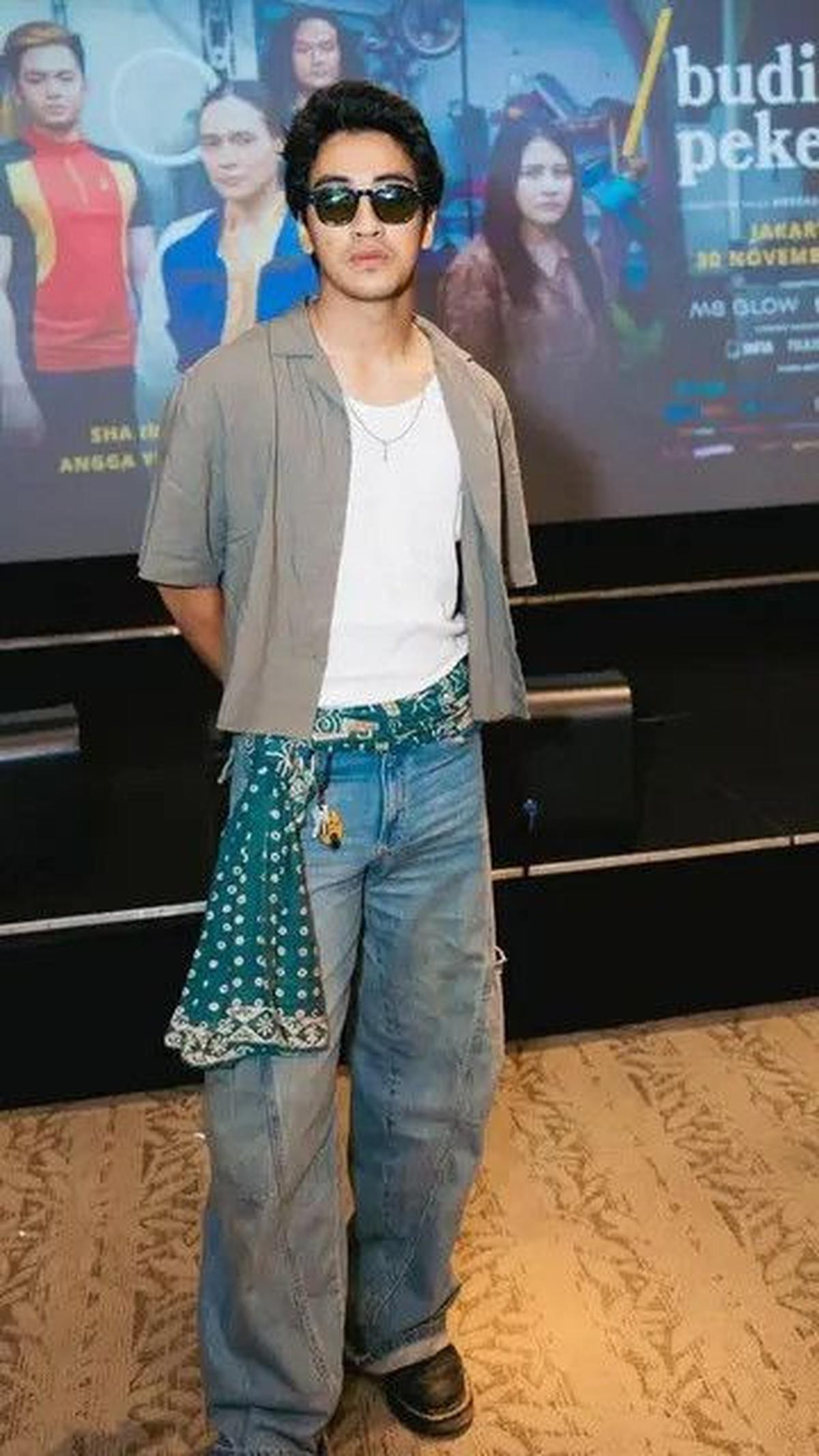Abidzar terlihat keren dengan paduan kaus putih, cropped shirt abu-abu, celana jeans, dan selendang batik hijau sebagai belt.