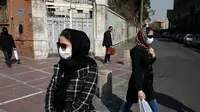 Warga Iran terlihat memakai masker sebagai upaya perlindungan dari Virus Corona yang telah menyebar luas di negara tersebut. (AP/ Vahid Salemi)