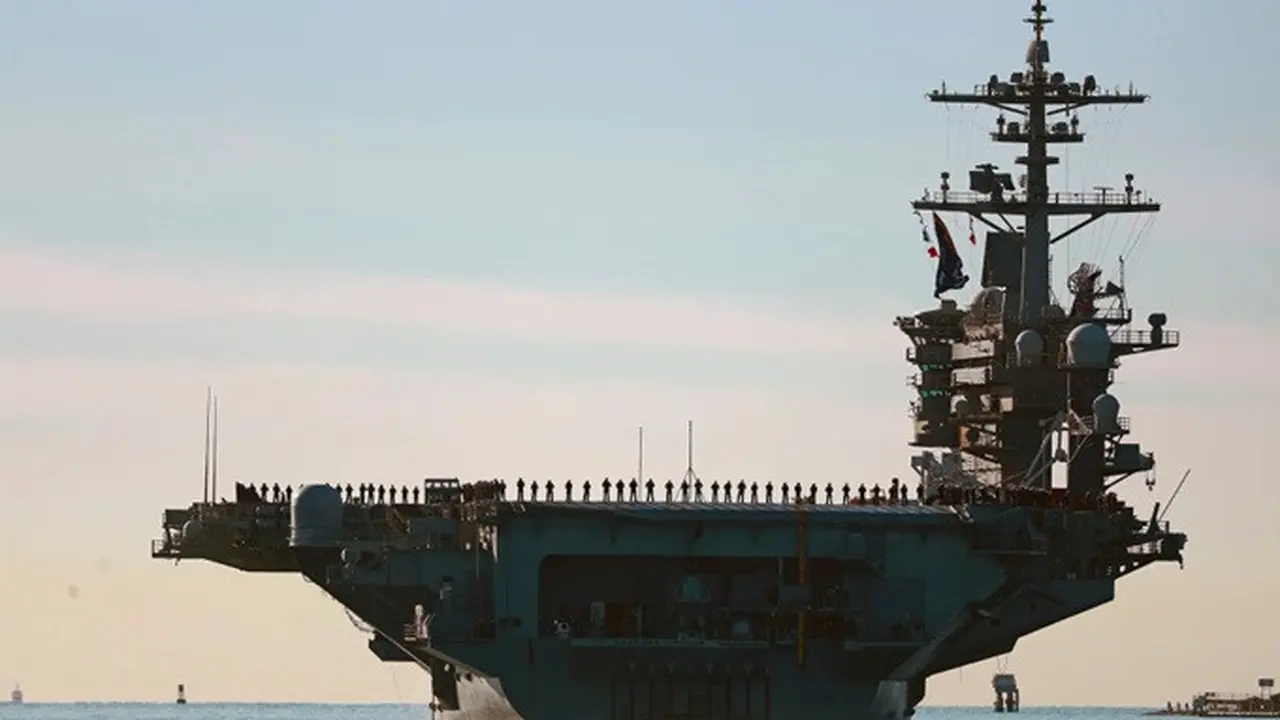 Para pelaut dan anggota Marinir AS berbaris di dek kapal induk USS Abraham Lincoln (CVN-72) saat kapal tersebut berangkat dari San Diego untuk menjalani penugasan pada 3 Januari 2021.
