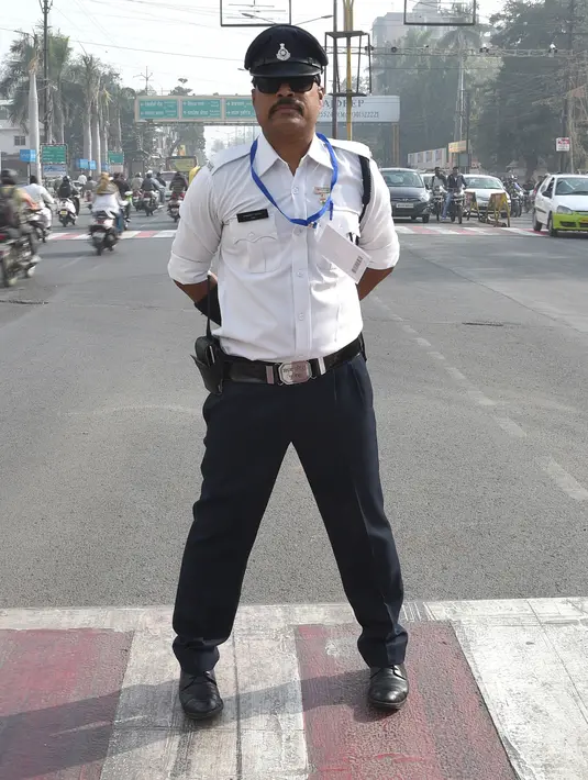 Polisi lalu lintas India Ranjeet Singh berpose saat berdiri di tengah jalan persimpangan Indore, India (22/12). Ranjeet Singh memiliki kumis bergaya Freddie Mercury namun suka menari moonwalk ala Michael Jackson. (AFP Photo/Indranil Mukherjee)