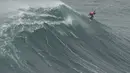 Peselancar Lucas Chianca melakukan putaran udara 360 saat keluar dari ombak selama kompetisi selancar ombak besar Nazare Tow Challenge di Praia do Norte, atau Pantai Utara, di Nazare, Portugal, Kamis, 10 Februari 2022. (AP Photo/Armando Franca)