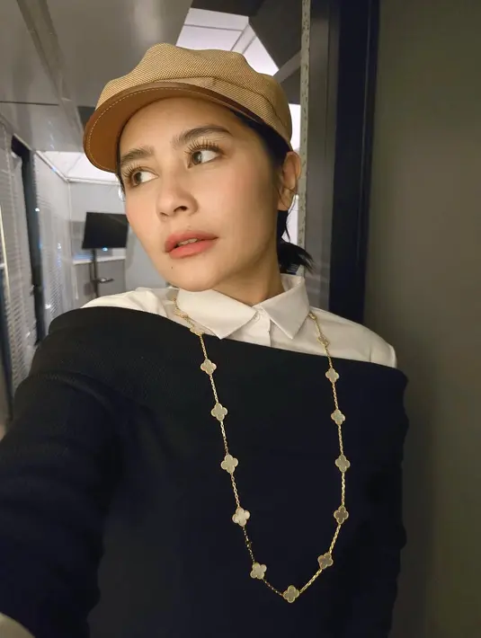 Dalam foto kiri, Prilly tampil memukau dengan white-collar shirt yang dilapis dengan sweater hitam klasik yang dikenakan off-shoulder, menciptakan siluet elegan namun tetap effortless.  [@prillylatuconsina96].