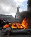 Sebuah mobil terbakar di Lapangan République saat aksi demonstrasi menentang kenaikan biaya hidup dan menyuarakan keluhan mahasiswa di Paris, Prancis, Sabtu (17/10/2026). (AP Photo/Thibault Camus)