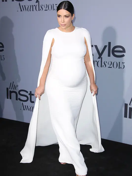 Kim Kardashian pun tampak cantik dengan gaun putih saat memamerkan kehamilannya. (REX-Shutterstock/HollywoodLife)