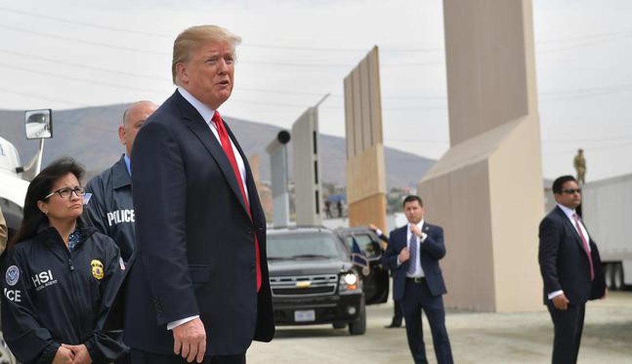 Presiden AS, Donald Trump meninjau prototipe tembok perbatasan AS dan Meksiko yang kontroversial di San Diego, Selasa (13/3). Prototipe tembok perbatasan Trump memiliki tinggi sekitar 9 meter, dengan puncak yang tebal dan bundar. (MANDEL NGAN / AFP)