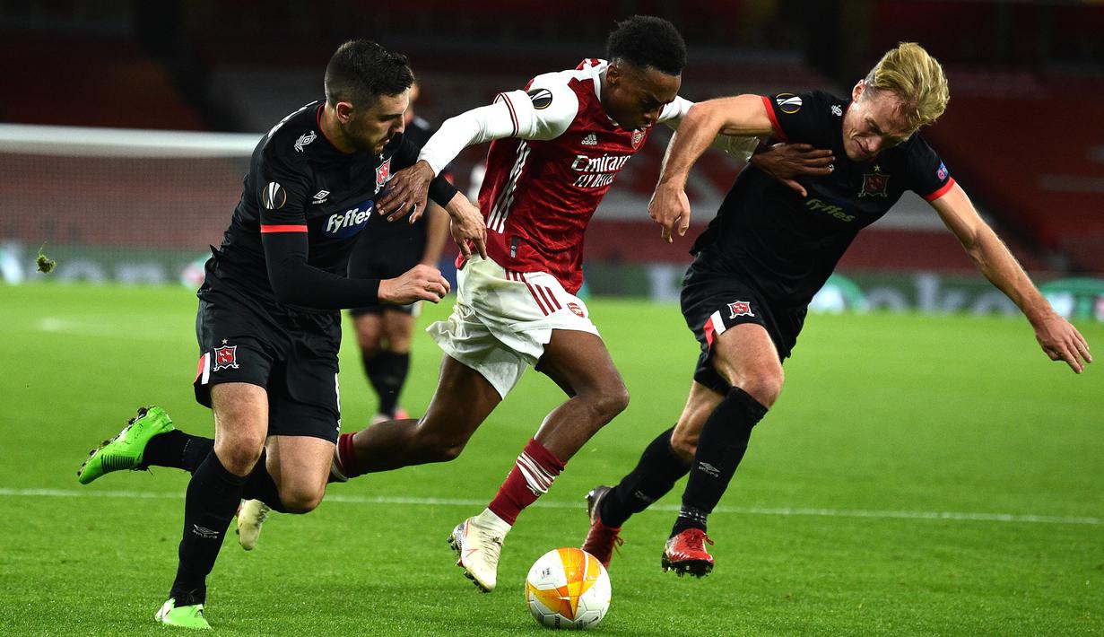 Gelandang Arsenal, Joe Willock, berusaha melewati dua pemain Dundalk pada laga lanjutan Liga Europa 2020/2021 di Emirates Stadium, Jumat (30/10/2020) dini hari WIB. Arsenal menang 3-0 atas Dundalk. (AFP/Glyn Kirk)
