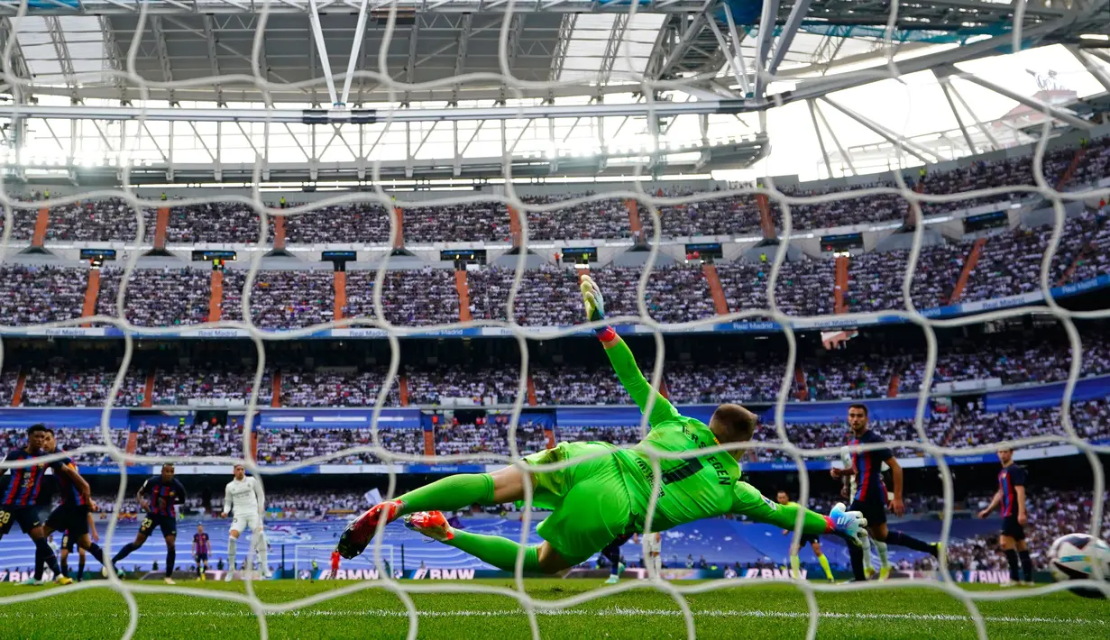 Pemain Real Madrid, Federico Valverde (kiri belakang) mencetak gol kedua timnya melewati kiper Barcelona Marc-Andre ter Stegen selama pertandingan sepak bola La Liga Spanyol antara Real Madrid dan Barcelona di Stadion Santiago Bernabeu, Madrid, Minggu (16/10/2022). (AP Photo/Manu Fernandez)