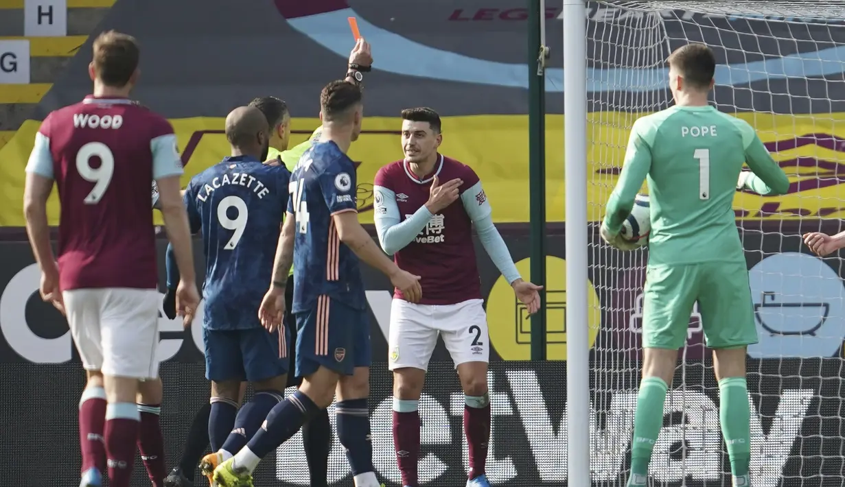 Bek Burnley, Erik Pieters menerima kartu merah dari wasit Andre Marriner saat menghadapi Arsenal yang akhirnya dianulir setelah wasit menyaksikan VAR dalam laga lanjutan Liga Inggris 2020/21 di Turf Moor, Burnley, Sabtu (6/3/2021). Burnley bermain imbang 1-1 dengan Arsenal. (AP/Jon Super/Pool)