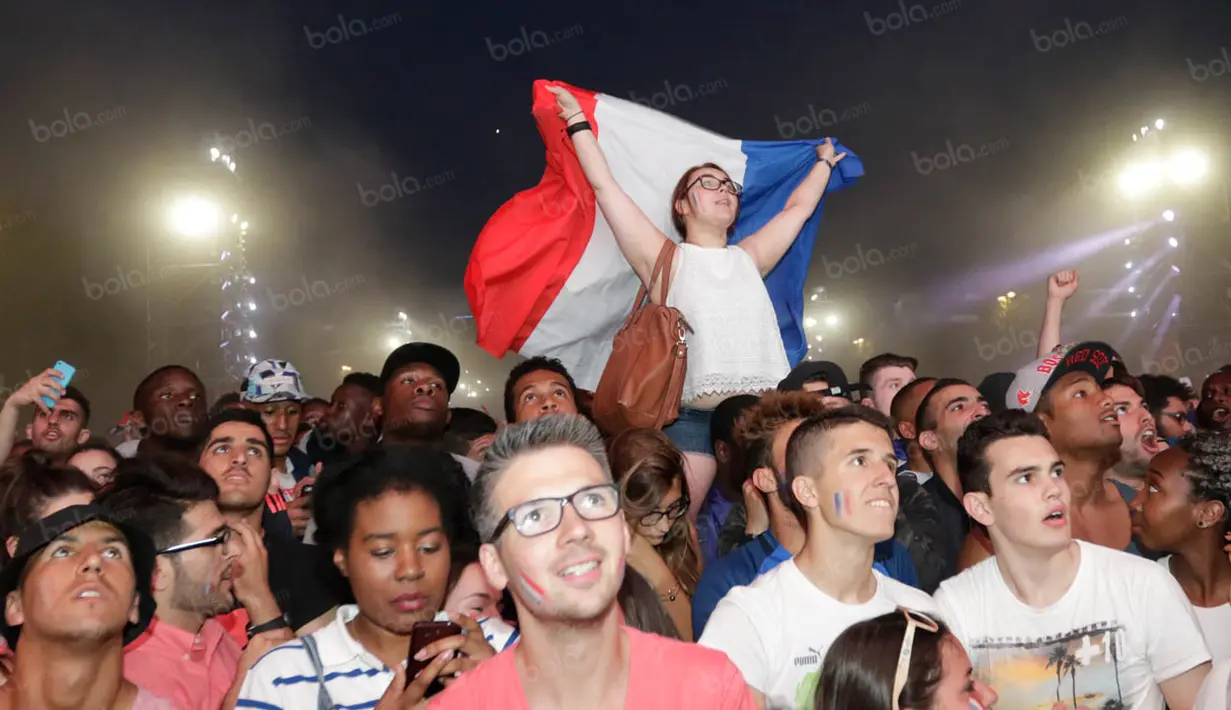 Sambil mengangkat bendera, warga Prancis merayakan kemenangan dengan skor 2-0 atas Jerman. (Bola.com/Vitalis Yogi Trisna)