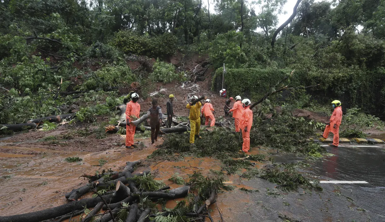 Petugas pemadam kebakaran membersihkan jalan setelah tanah longsor yang disebabkan oleh curah hujan di Mumbai, India, Rabu, (6/8/2020). Musim hujan India berlangsung dari Juni hingga September. (AP Photo / Rafiq Maqbool)