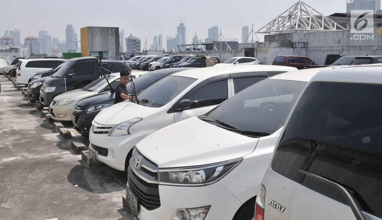 Seorang pria di antara kendaraan yang terparkir di salah satu pusat perbelanjaan di kawasan Jakarta, Selasa (20/8/2019). Pemprov DKI Jakarta tengah mengkaji rencana untuk menaikkan tarif parkir di ibu kota sebagai bagian dari usaha mengurangi kemacetan dan polusi udara. (merdeka.com/Iqbal S Nugroho)